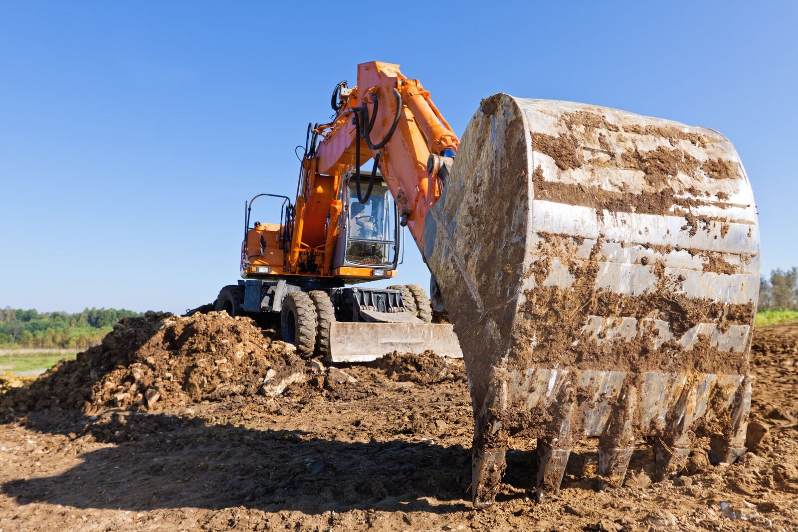 Excavadora moviendo tierra con cucharón cargado